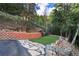 Nicely landscaped backyard with retaining wall, stone sidewalk, and custom seating at 1194 Snyder Mountain Rd, Evergreen, CO 80439