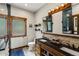 Inviting bathroom with double vanity, wood accents, and a walk-in shower at 1194 Snyder Mountain Rd, Evergreen, CO 80439