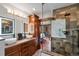 Modern bathroom featuring double sinks, granite countertops, wood cabinets, and a glass-enclosed shower at 1194 Snyder Mountain Rd, Evergreen, CO 80439