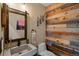 Charming powder room featuring a unique reclaimed wood accent wall and rustic vanity at 1194 Snyder Mountain Rd, Evergreen, CO 80439