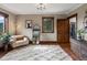 Comfortable bedroom with hardwood floors, a cozy chair, and a view of the trees outside the window at 1194 Snyder Mountain Rd, Evergreen, CO 80439