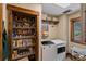 Convenient laundry room with washer, dryer, pantry, and storage shelves at 1194 Snyder Mountain Rd, Evergreen, CO 80439