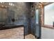 Nicely tiled stand up shower with stone floor and glass door at 1194 Snyder Mountain Rd, Evergreen, CO 80439