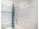 Bathroom with bathtub, glass shelves, and teal shower curtain at 6700 W 11Th Ave # 205, Lakewood, CO 80214