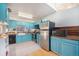 Kitchen with teal cabinets, stainless steel appliances, and wood countertops at 6700 W 11Th Ave # 205, Lakewood, CO 80214