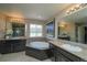 A stunning bathroom with dual sinks, granite countertops, and a soaking tub with dark wood trim at 14193 Double Dutch Cir, Parker, CO 80134