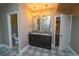Elegant bathroom with double vanity, granite countertops, chandelier lighting and decorative tile flooring at 14193 Double Dutch Cir, Parker, CO 80134