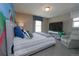 Neutral toned bedroom features a twin bed, large window and a comfortable recliner at 14193 Double Dutch Cir, Parker, CO 80134