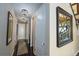 Hallway featuring dark hardwood floors, neutral walls, decorative mirrors, and modern chandeliers at 14193 Double Dutch Cir, Parker, CO 80134