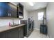 Modern laundry room features front-load washer and dryer, stylish cabinets, and neutral tiled floors at 14193 Double Dutch Cir, Parker, CO 80134