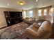 Living room with hardwood floors, multiple sofas, TV, and windows with custom curtains at 14193 Double Dutch Cir, Parker, CO 80134