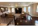 Living room featuring hardwood floors, multiple sofas, TV, and windows with modern curtains at 14193 Double Dutch Cir, Parker, CO 80134
