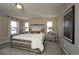 Inviting main bedroom with plush carpeting, tufted headboard, mirrored nightstands, and soft natural light from windows at 14193 Double Dutch Cir, Parker, CO 80134