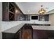 Wet bar with granite countertops, stainless steel appliances, dark cabinets and a tiled backsplash at 14193 Double Dutch Cir, Parker, CO 80134