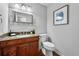 Bathroom featuring wood vanity with granite counters and a toilet at 8896 W Prentice Ave, Littleton, CO 80123