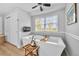 Luxurious bathroom featuring a soaking tub, wainscoting, and modern fixtures at 8896 W Prentice Ave, Littleton, CO 80123