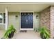 Charming front door with brick accents, updated hardware, and vibrant ferns at 8896 W Prentice Ave, Littleton, CO 80123