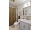 Compact bathroom with a neutral shower curtain, white vanity, and coordinated fixtures at 2083 W Arbor Ave, Littleton, CO 80120