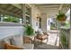 Charming front porch with seating area, hanging plants, and vintage-style string lighting at 2083 W Arbor Ave, Littleton, CO 80120