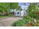 Inviting curb appeal showcasing lush landscaping, mature trees, and a quaint covered porch at 2083 W Arbor Ave, Littleton, CO 80120