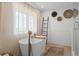 Bright bathroom featuring a standalone soaking tub, elegant fixtures, and a neutral palette at 30484 Chisholm Trl, Elizabeth, CO 80107