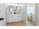 Bright bathroom with a double vanity, round mirrors, and a standalone soaking tub at 30484 Chisholm Trl, Elizabeth, CO 80107
