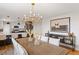 Stylish dining area with a wooden table, modern chandelier, and open access to the kitchen at 30484 Chisholm Trl, Elizabeth, CO 80107
