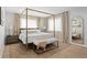 Bright main bedroom with a four poster bed, bench, neutral carpet and drapes at 30484 Chisholm Trl, Elizabeth, CO 80107