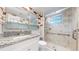 Modern bathroom featuring a granite countertop vanity and a glass-enclosed shower with marbled tile at 11718 Keough Dr, Northglenn, CO 80233