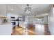 Open concept kitchen with white cabinets, stainless appliances, and granite island flowing to the living area at 11718 Keough Dr, Northglenn, CO 80233