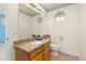 Classic bathroom with granite vanity, round window, and a conveniently located toilet at 2573 S Troy Ct, Aurora, CO 80014