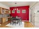 Dining room featuring hardwood floors, statement red wall, modern chandelier, and glass doors to the outside deck at 2573 S Troy Ct, Aurora, CO 80014