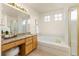 Bright main bathroom with soaking tub, glass shower, and granite vanity with a makeup table at 2573 S Troy Ct, Aurora, CO 80014