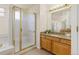 Updated main bathroom showcasing tile floors, granite counters, and glass shower doors at 2573 S Troy Ct, Aurora, CO 80014