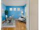 Office with blue walls, hardwood flooring, three windows, and modern furniture and decor at 2573 S Troy Ct, Aurora, CO 80014