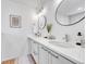 Bathroom features dual sinks, modern lighting, and sleek white cabinets at 1903 W 66Th Ave, Denver, CO 80221