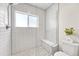 Modern bathroom featuring tiled shower, bench, and ample natural light at 1903 W 66Th Ave, Denver, CO 80221