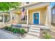 Inviting front porch with stylish blue door, covered seating area, and landscaped surroundings at 1903 W 66Th Ave, Denver, CO 80221