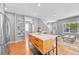 Bright and airy kitchen with a large island, stainless steel appliances, and hardwood floors at 1903 W 66Th Ave, Denver, CO 80221