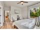 Bedroom with a view of trees, white linens, a ceiling fan, and a doorway to another room at 1308 Snowberry Ln # 302, Louisville, CO 80027