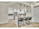 Bright, open kitchen featuring a breakfast bar with seating, white cabinets, and modern pendant lights at 1308 Snowberry Ln # 302, Louisville, CO 80027