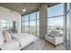 Bright bedroom features floor-to-ceiling windows showcasing city views, with modern ceiling fan and neutral tones at 1700 Bassett St # 1106, Denver, CO 80202