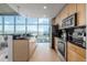 Modern kitchen with stainless steel appliances, ample counter space, and floor-to-ceiling windows offering stunning city views at 1700 Bassett St # 1106, Denver, CO 80202