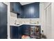Stylish wet bar featuring navy cabinets, quartz countertops, and a beverage refrigerator at 4150 Longview Ln, Boulder, CO 80301