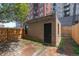 Backyard featuring a brick patio, fence, grass, and a small shed at 1650 N Pennsylvania St, Denver, CO 80203