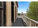 Balcony featuring brick, black trim, white railings, with a treetop view of the city at 1650 N Pennsylvania St, Denver, CO 80203
