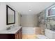 Bathroom featuring a vanity, toilet, bathtub, tiled walls and floor, and a window at 1650 N Pennsylvania St, Denver, CO 80203