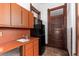 Compact kitchen featuring orange cabinets, stainless steel appliances, and hardwood door at 1650 N Pennsylvania St, Denver, CO 80203