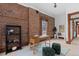Bright office with exposed brick wall, a wooden desk, and large window for natural light at 1650 N Pennsylvania St, Denver, CO 80203