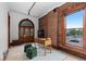 Well-lit office featuring an exposed brick wall, wooden desk, and view of the city at 1650 N Pennsylvania St, Denver, CO 80203